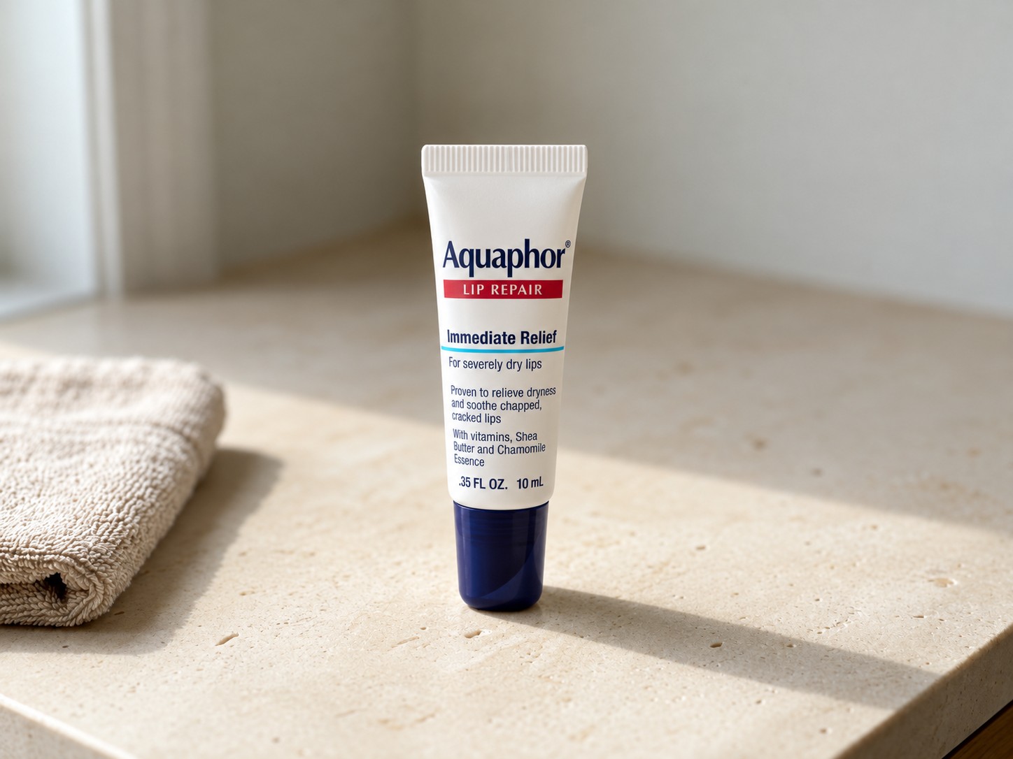 Aquaphor Lip Repair Ointment on a warm stone vanity
