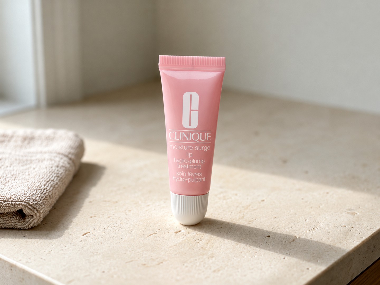 Clinique Moisture Surge Lip Hydro-Plump Treatment on a warm stone vanity