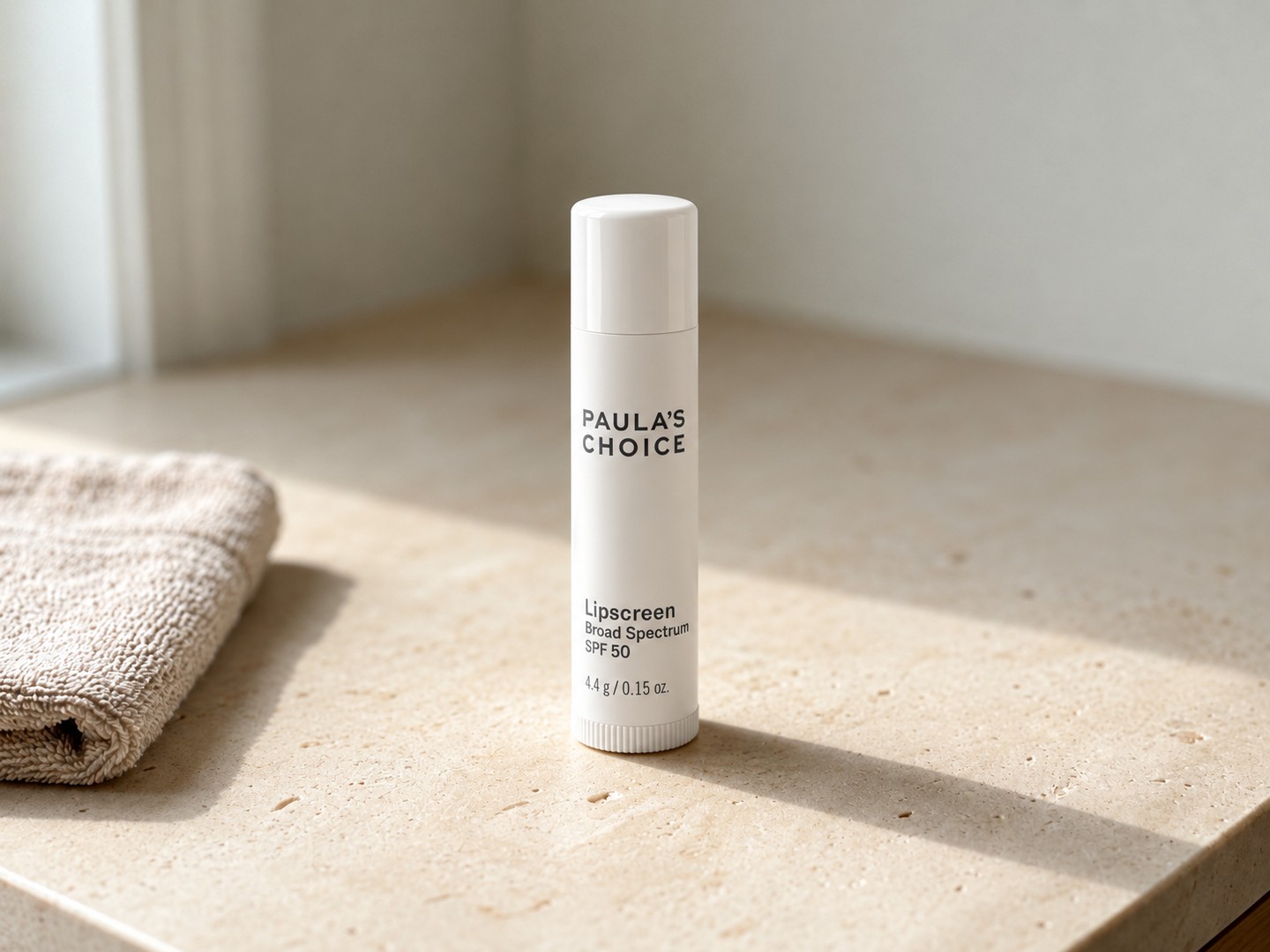 Paula’s Choice Lipscreen SPF 50 on a warm stone vanity